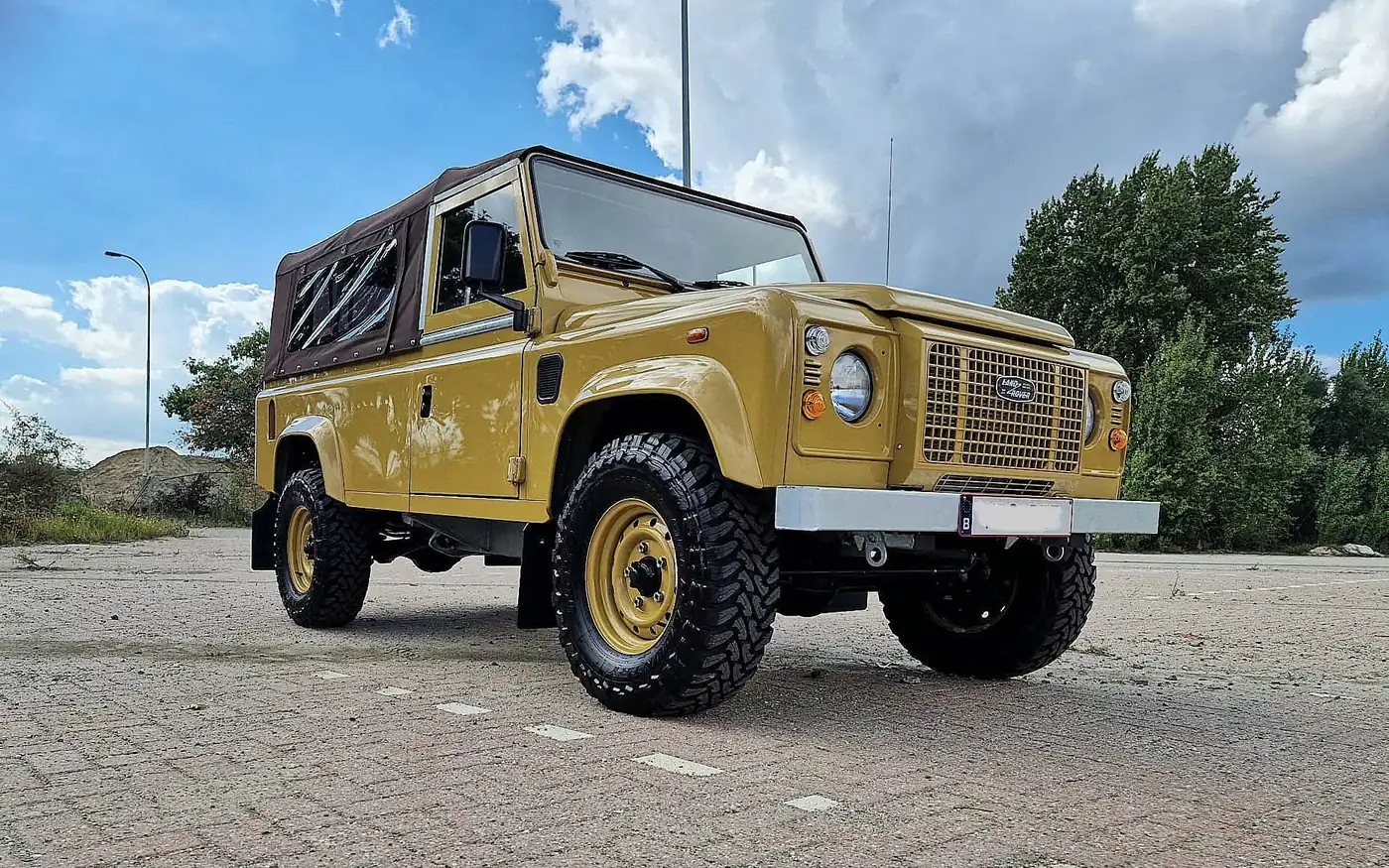 Land Rover Defender 110 soft top in zandgeel, opgebouwd door Desert Foxx