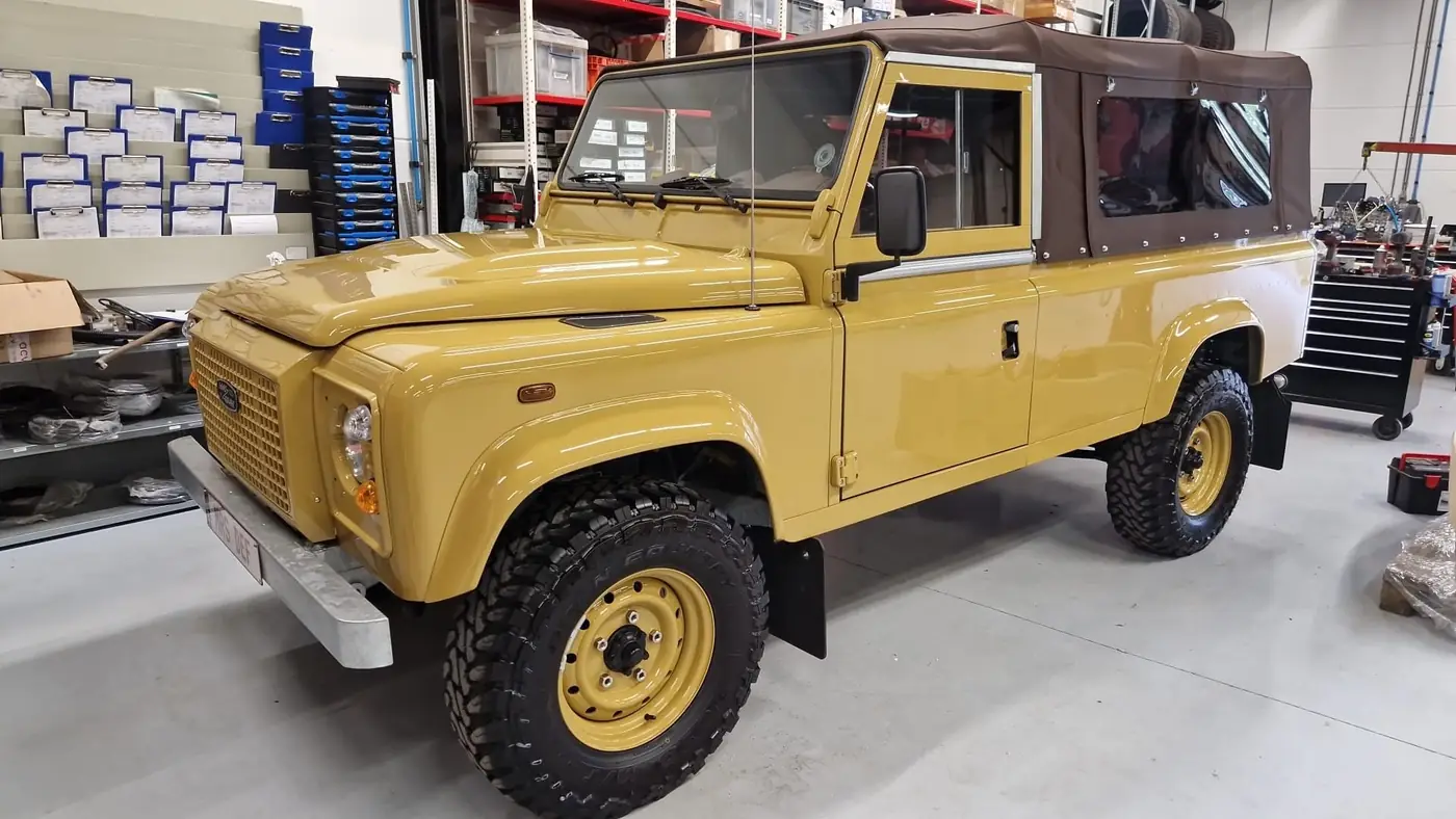 Land Rover Defender 110 soft top in zandgeel, opgebouwd door Desert Foxx