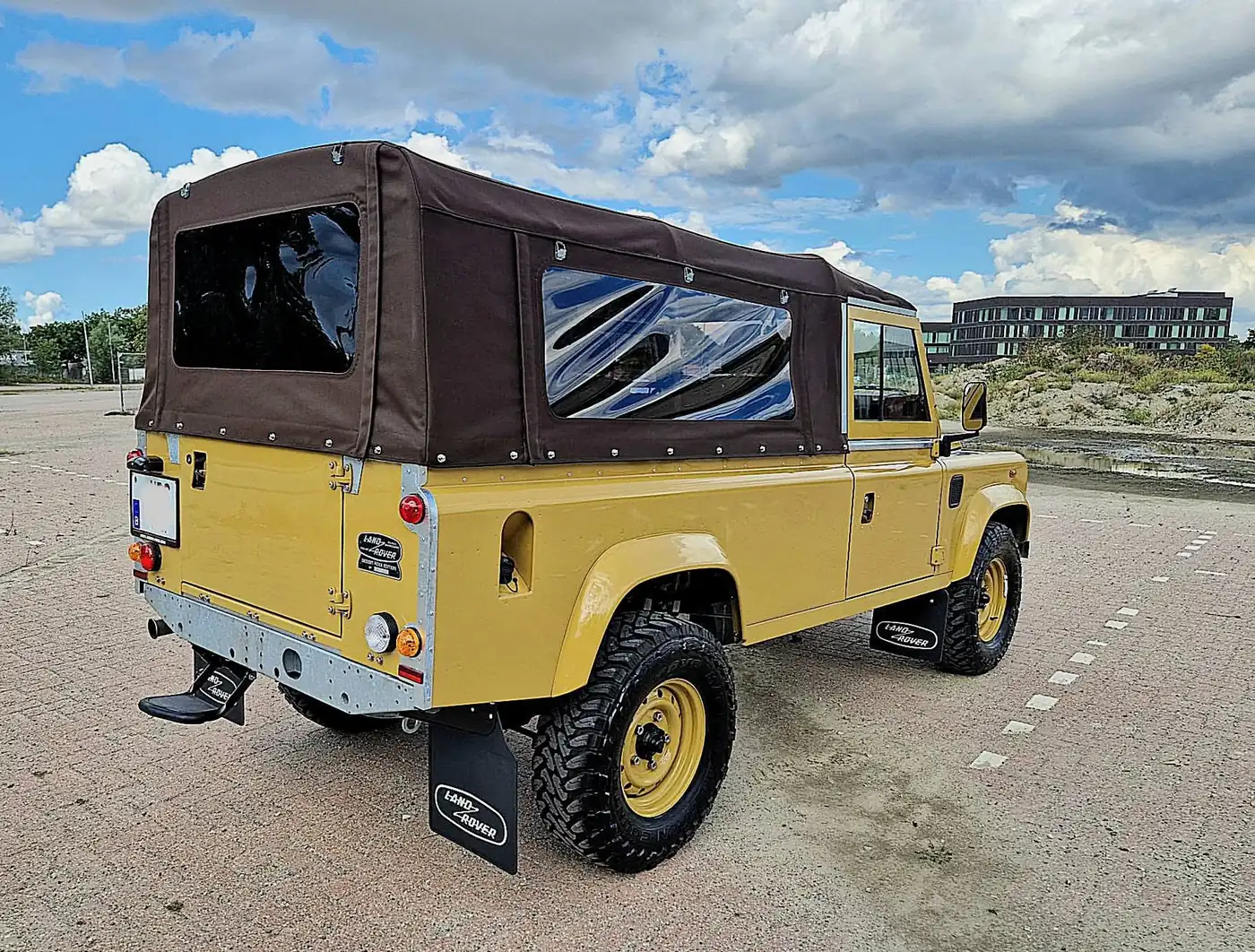 Land Rover Defender 110 soft top in zandgeel, opgebouwd door Desert Foxx
