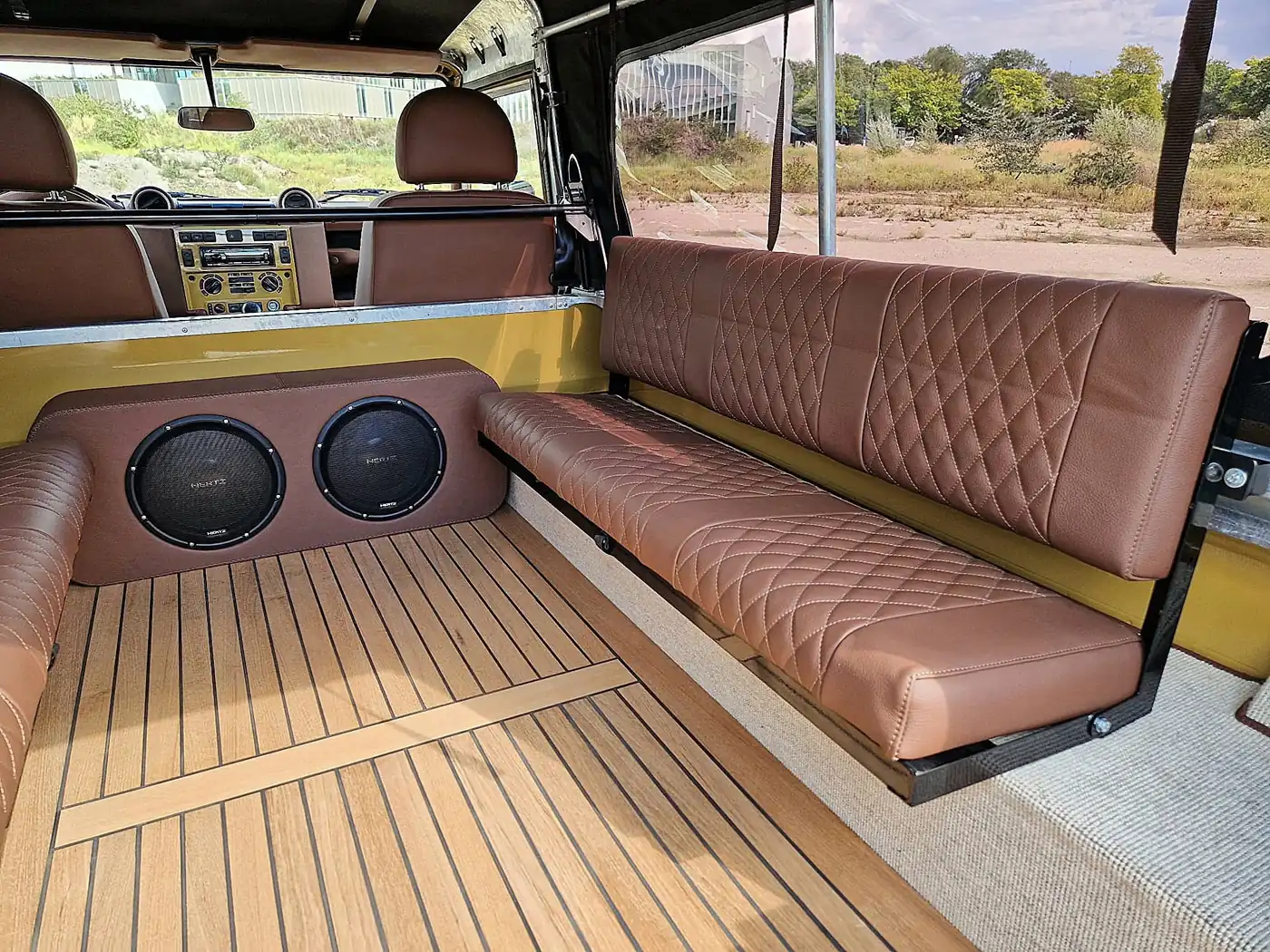 Land Rover Defender 110 soft top in zandgeel, opgebouwd door Desert Foxx