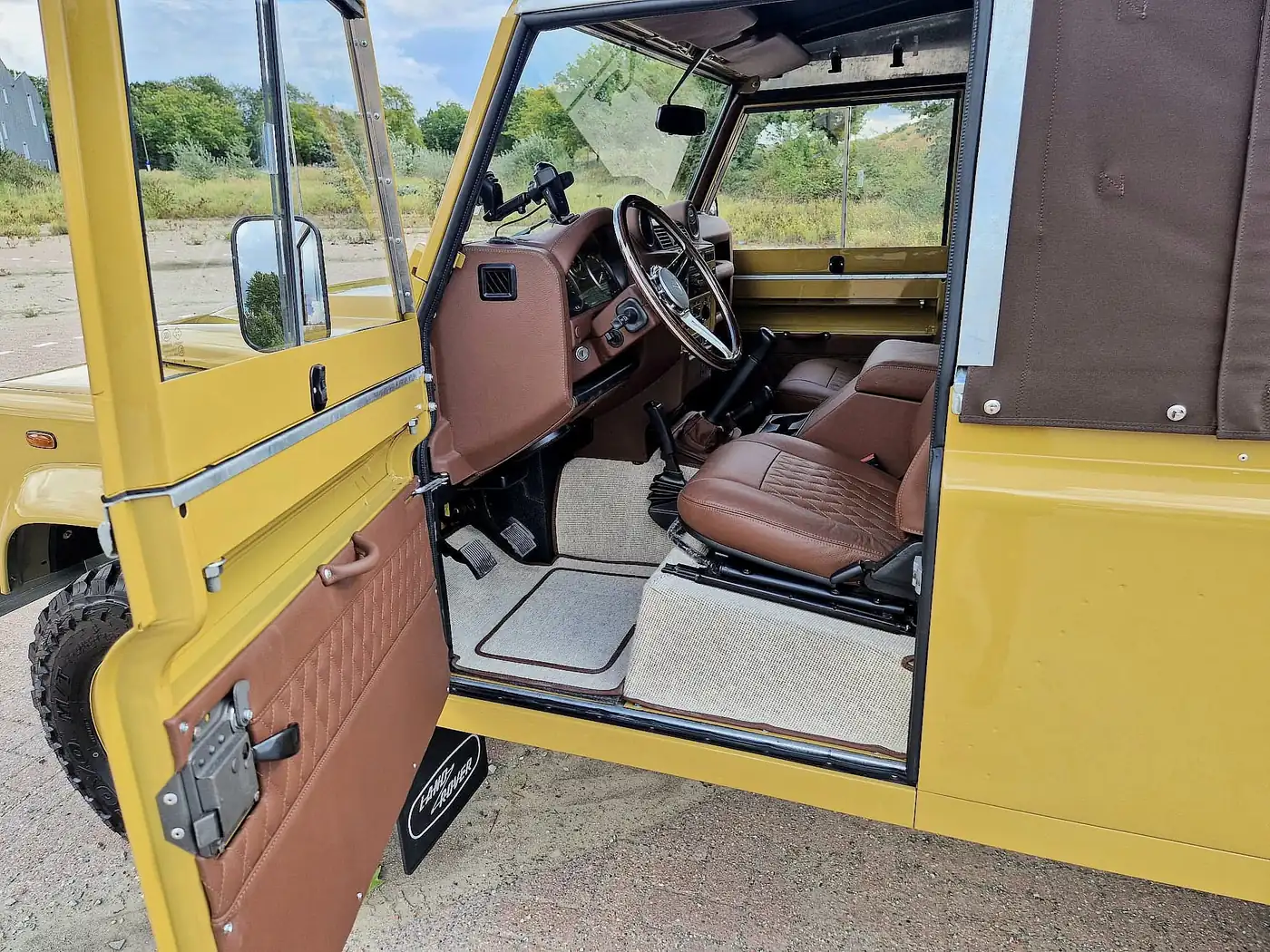 Land Rover Defender 110 soft top in zandgeel, opgebouwd door Desert Foxx