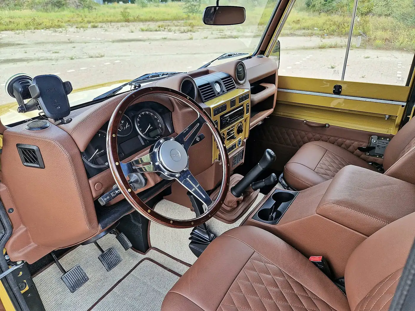 Land Rover Defender 110 soft top in zandgeel, opgebouwd door Desert Foxx