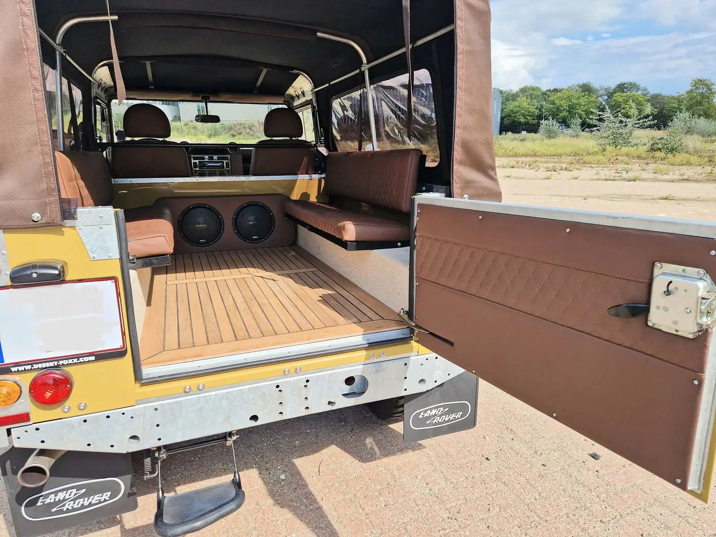 Land Rover Defender 110 soft top in zandgeel, opgebouwd door Desert Foxx