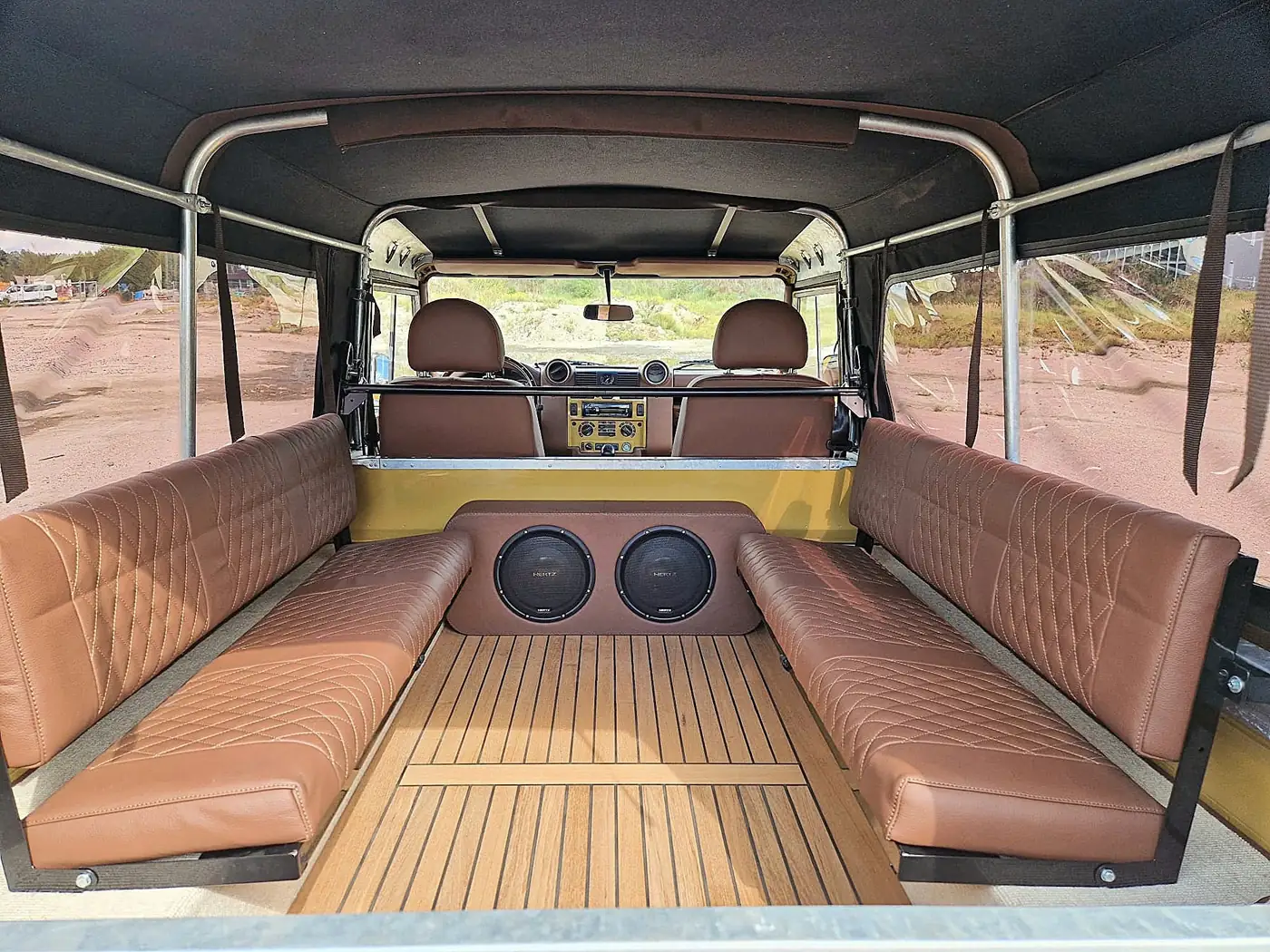 Land Rover Defender 110 soft top in zandgeel, opgebouwd door Desert Foxx