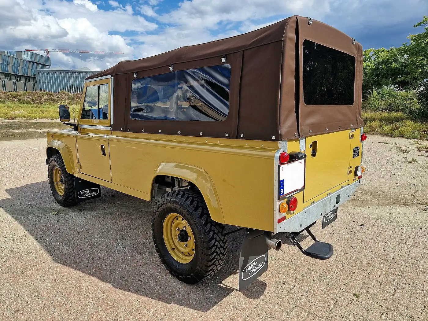 Land Rover Defender 110 soft top in zandgeel, opgebouwd door Desert Foxx